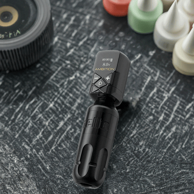 Ambition Stroke 4.0mm Rotary Tattoo Machine in black, featuring sleek design and LCD display, placed on textured surface.